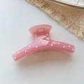 Detail einer lichtdurchlässigen rosa Haarklammer mit weißen Punkten und Metallfeder - Rosa Kleiderbügel-Design