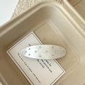 Detalle de la pinza ovalada de acetato con textura blanco lunar y diamantes de imitación - Clip de resorte blanco