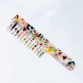 Detail of vintage marble pattern acetate comb showing wide and fine teeth design - Rainbow