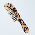 Close-up of wide-tooth acetate hair comb with amber marble texture and smooth handle - 3mm Acetate / Light Leopard