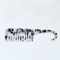 Macro detail of wide-tooth acetate comb with marble texture and hanging hook handle - Milk White