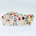 Macro-opname van de acetaat haarkam met artistieke kleurrijke steenpatronen en texturen - Regenboog