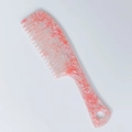 Macro detail of wide-tooth hair comb featuring pink marble acetate and ergonomic handle - Pink