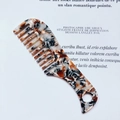 Macro detail of tortoiseshell acetate wide-tooth comb with an ergonomic hanging handle - Beige