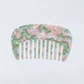 Macro shot of marble textured acetate hair comb with mint green and pink pastel patterns - Pink & Green
