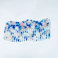 Macro shot of a wavy wide-tooth comb featuring blue and pink marble acetate patterns - Blue White