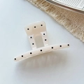 Pince à cheveux motif à pois sur résine blanc crème posée sur un tapis texturé - Style Droit Blanc