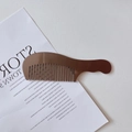 Detalle del mango ergonómico y las púas anchas de este peine para el cabello marrón carey - Marrón
