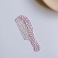 Makroaufnahme des grobzinkigen Acetat-Kamms mit rosa Marmortextur und Wellengriff - Rosa