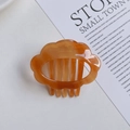 Detail of amber acetate resin hair comb with elegant hollow cloud design and sturdy teeth - Caramel color