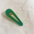 Detalle de una pinza para el pelo de acetato verde con mecanismo de resorte metálico dorado - Verde