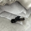 Détail d'une barrette nœud noire brillante faite à la main avec étiquette dorée - Noir