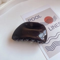 Macro-opname van de gepolijste zwarte acetaat haarklem met zijn sterke tanden - Dumpling Vorm / 8cm*4cm