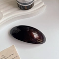 Detail view of handmade dark brown acetate spring hair clip with gold lettering - Brown