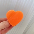 Vista detallada de la pinza de corazón naranja brillante con un acabado de resina - Naranja