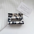 Detail of a rectangular acetate hair claw clip with black and white marble pattern texture - 6cm*4cm