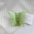 Dettaglio della pinza per capelli a farfalla verde chiaro con finitura perlata e design - 7cm x 4,5cm / Verde
