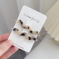 Paar gegolfde haarclips van acetaat met schildpadpatroon op een sieradenkaart - Lichte Luipaardprint
