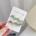 Set van golvende acetaat haarklemmen met pastel verloop op een witte displaykaart - Metaalgroen
