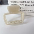 Detail der cremefarbenen Haarklammer mit Marmormuster und Creation France Gravur - Irisierendes Weiß