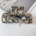 Detail view of acetate marble hair claw with gold France handmade logo engraving - Artistic Marble Pattern Style (FZ425) / Mottled Blue-Green Coffee
