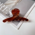 Close-up of amber acetate hair claw clip showing the FRANCE Handmade stamp detail - Caramel color