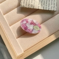Detailaufnahme der Haarspange aus Acetat mit rosa Marmormuster und goldenem Etikett - 4cm*2.5 / Rosa & Weiß