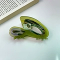 Close-up of olive green acetate hair claw with marble pattern and France Handmade text - Green