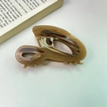 Retro handmade acetate hair claw clip with milk tea marble finish on open book background - Caramel color