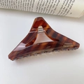 Detail of dark brown tortoiseshell acetate triangle hair claw with gold France Handmade logo - Textured Brown