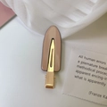 Detailansicht einer nackten Acryl-Haarklammer mit goldener Metallbasis auf weichem Grund - Milchtee-Farbe