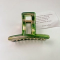 Minimalist green acetate hair claw clip with golden metal spring on a white background - Emerald Green Yellow Tortoiseshell / Green