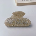 Detail of a marble acetate claw clip with sparkling rhinestone smiley faces - Beige