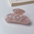 Close-up of pink marble acetate hair claw clip featuring three sparkling rhinestone smileys - Pink