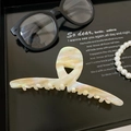 Detail of large acetate shark hair claw with iridescent marble texture on black tray - 6# Textured Platinum