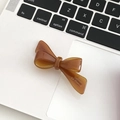 Elegant amber acetate bow hair clip with gold Barrette La France lettering on laptop - Caramel color