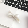 Elegant white acetate bow hair clip with gold La France lettering on a keyboard - Jade White