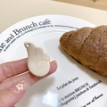 Détail de la pince à cheveux crème en forme de cœur avec strass sur une assiette - Poche zippée