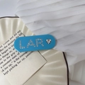 Blauwe acetaat haarklem met sprankelende strass LAR-letters en een hartvormig detail - Blauw