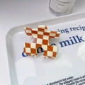 Détail d'une pince à cheveux à carreaux orange et blanc en acétate dans un plateau blanc - 5# Café