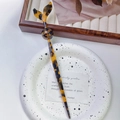 Detail van schildpadkleurige acetaat haarstok met vissenstaartontwerp voor elegante kapsels - Luipaardprint