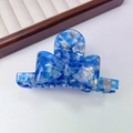 Detailed close-up of blue and white acetate bow hair claw clip with France Handmade text - Blue