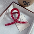 Dettaglio di una pinza per capelli rossa lucida con design a incrocio su sfondo vintage - 12# Pinza per Capelli Piccola Incrociata