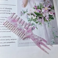 Pink marble acetate hair comb with wide teeth and pointed tip on a magazine - Pink White