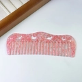 Nahaufnahme eines rosafarbenen Azetat-Haarkamms mit dekorativen Herz-Ausschnitten - Stärke 3mm / 2# Schneeflockenrosa