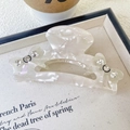 Dettaglio della pinza per capelli in acetato bianco con fiocco e decorazione in strass lucidi - Bianco