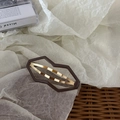 Barrette géométrique marron mat avec finition dorée dans un décor esthétique chaleureux - Calebasse Café