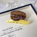 Detail of snail-shaped tortoise shell hair claw clip with metallic spiral on a tray - Snail Shape Style