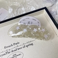 Detailed macro shot of cream acetic acid hair claw with sparkling star and moon patterns - Moon and Star Style