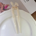 Close-up of rabbit-shaped acetate hair fork with cream marble texture and gold detailing - White